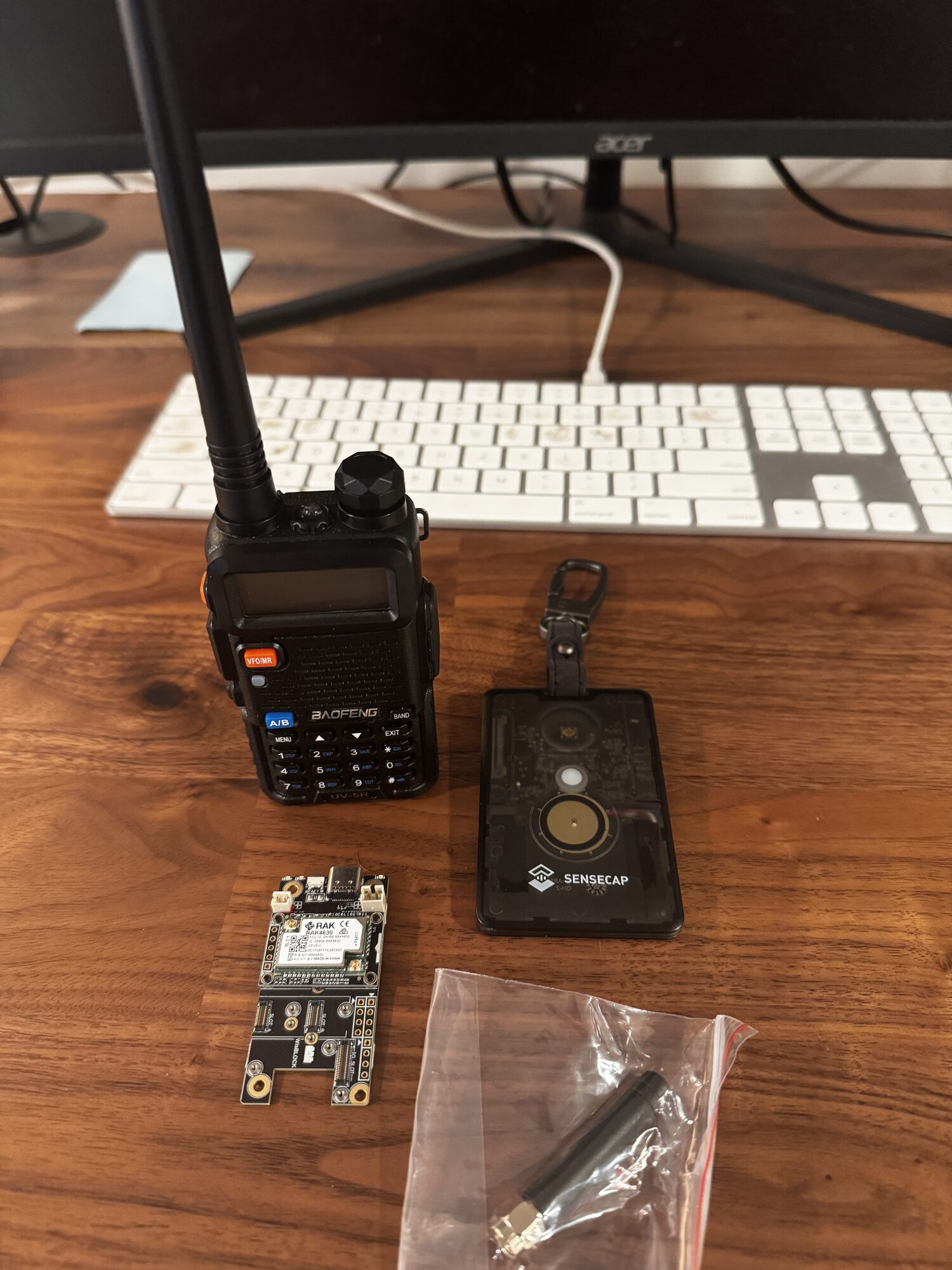 Haul on a desk: Baofeng UV-5R radio, SenseCAP card tracker, RAK board, and antenna